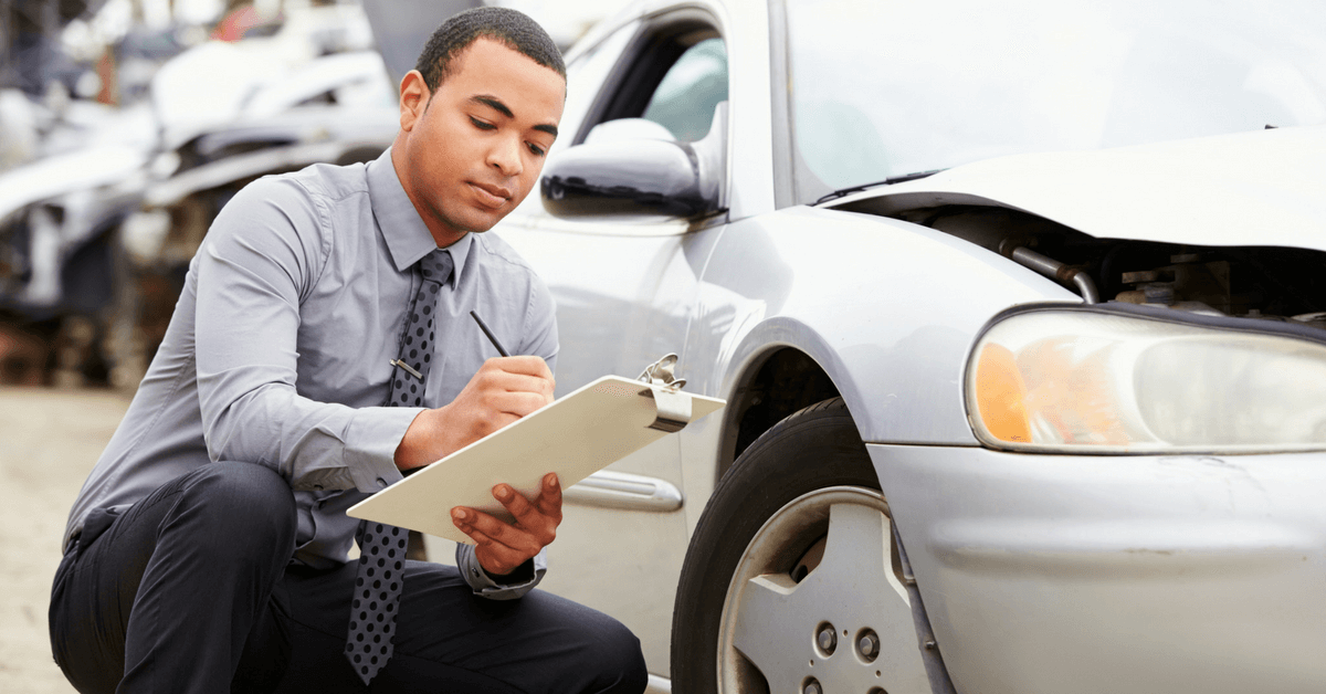 man-inspecting-car-damage