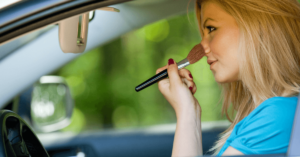 Driving distractions teen applying makeup