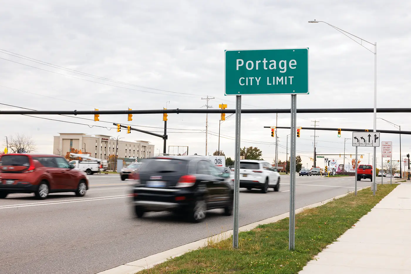 Traffic moves by an intersection near the Portage city limit sign, showing a roadway where a Michigan Auto Law handles car accident cases.