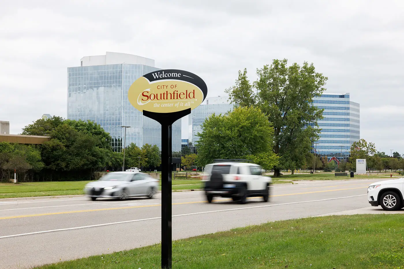 Passing cars near the City of Southfield welcome sign help illustrate the community served by a car accident lawyer in Southfield.