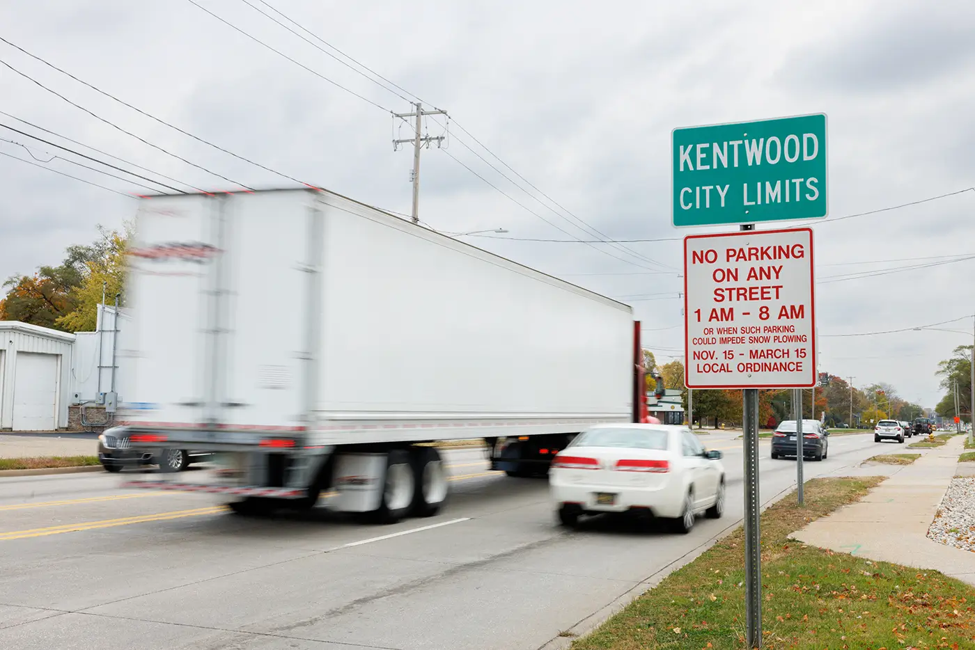 White semi-truck passing the Kentwood city limits sign, where Michigan Auto Law serves truck accident cases in Kentwood.