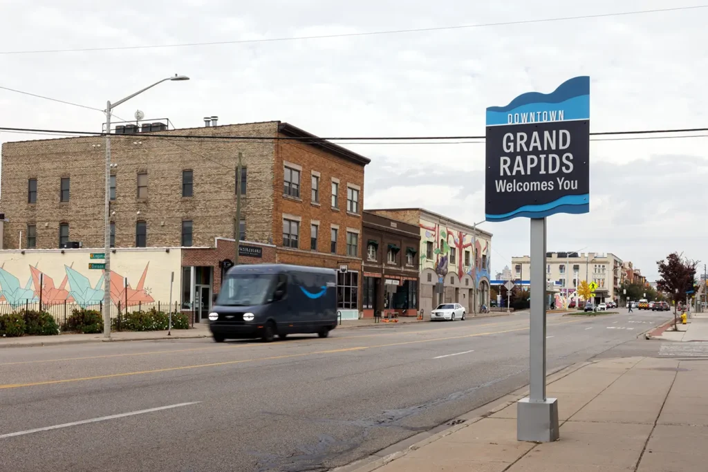 Downtown Grand Rapids welcome sign beside a busy street where truck crash lawyers in Grand Rapids may handle cases involving delivery vehicles and trucks.