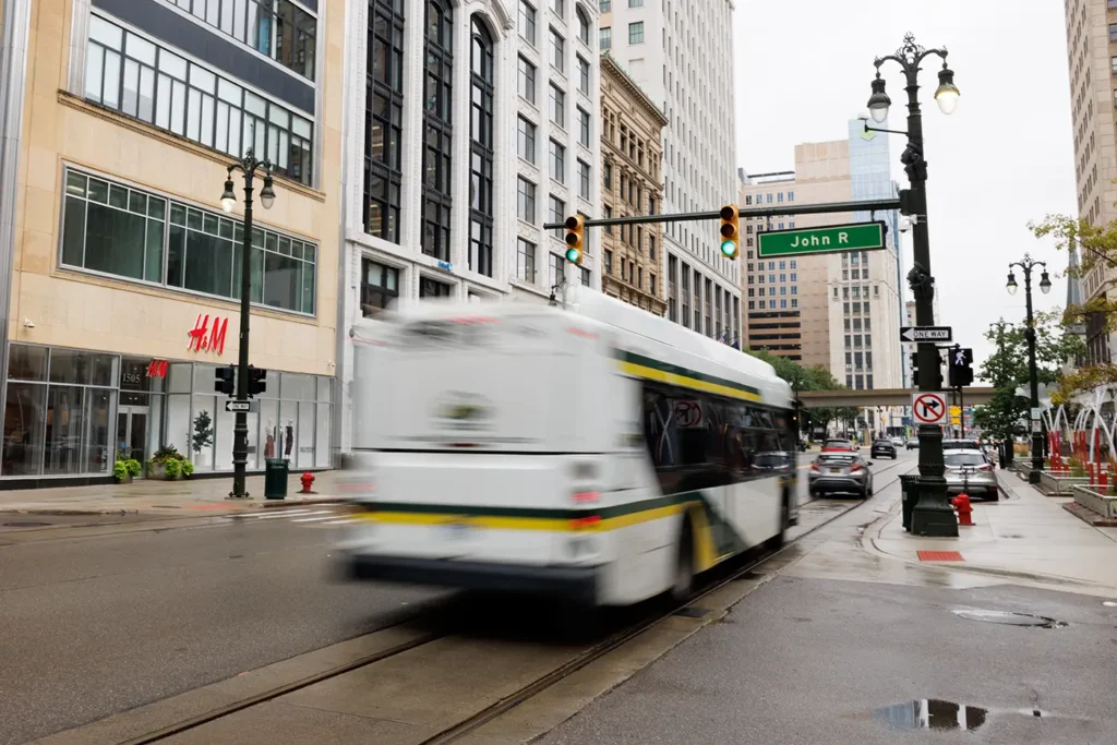 A city bus travels through downtown Detroit near John R Street, where Michigan Auto Law helps crash victims as a bus accident attorney in Detroit.