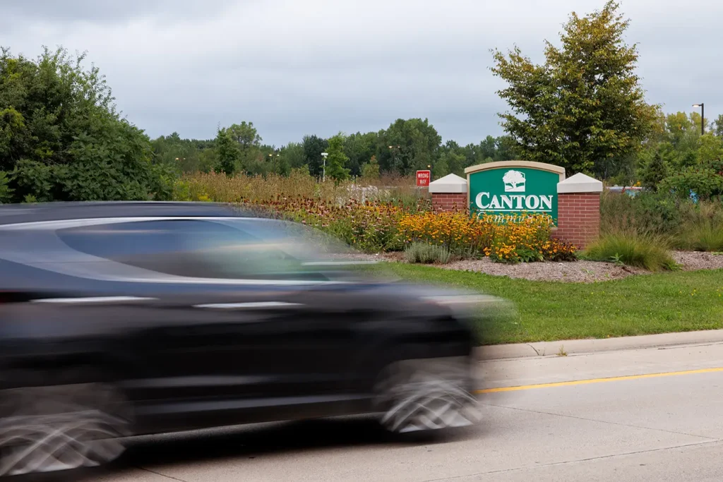 Passing car near the Canton community sign, representing Michigan Auto Law as a car accident lawyer in Canton.