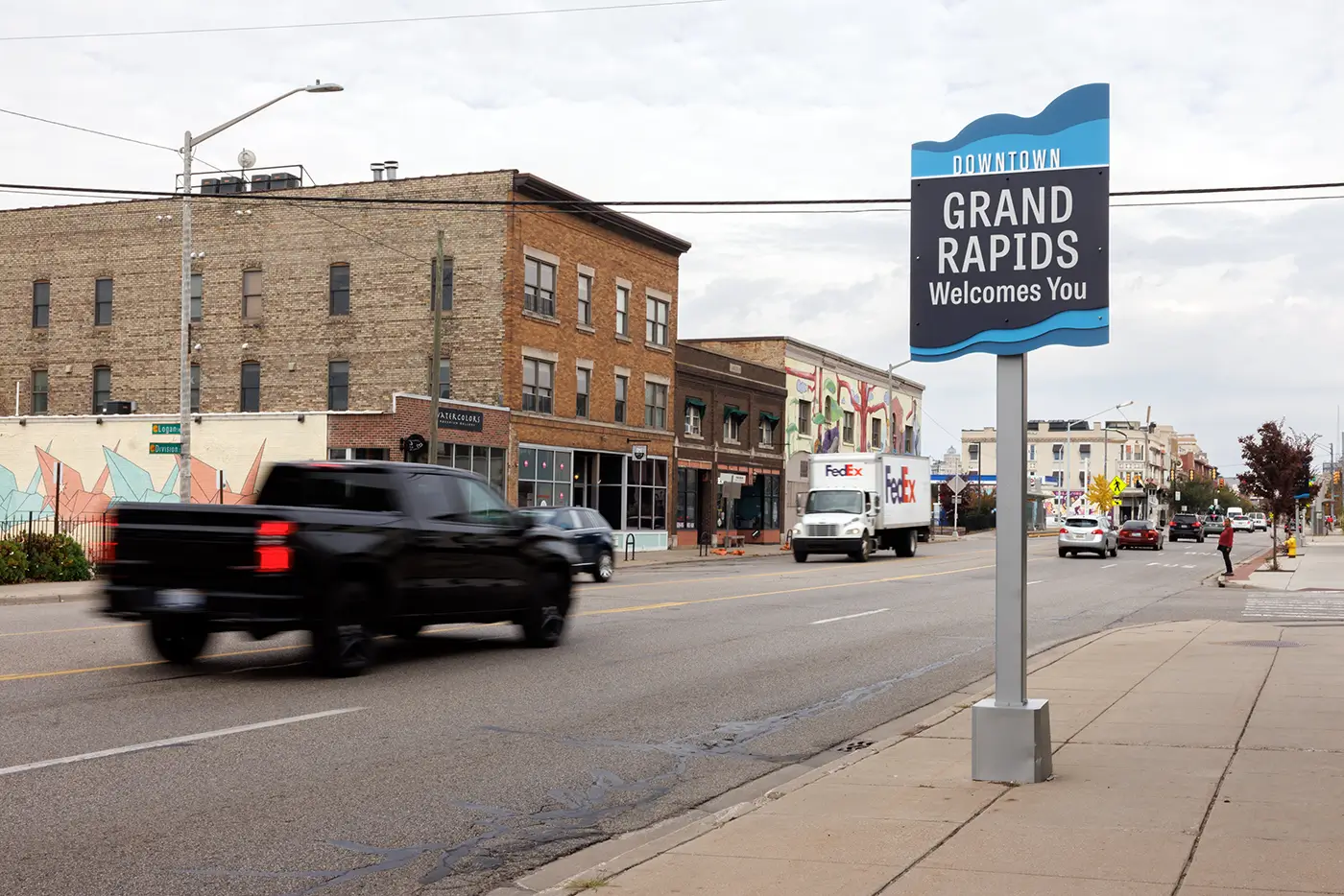 Downtown Grand Rapids welcome sign beside a busy road served by Michigan Auto Law, a car accident attorney in Grand Rapids.