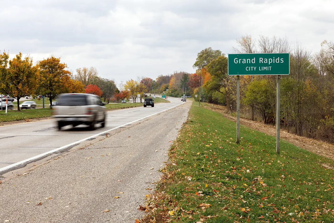 Cars drive past the Grand Rapids city limit sign, a setting where Michigan Auto Law helps crash victims as a car accident lawyer in Grand Rapids.