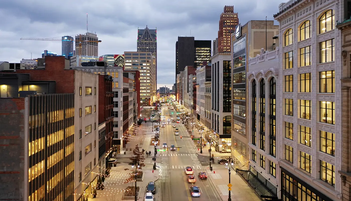 Detroit city street with evening traffic, showing Michigan Auto Law’s bus accident law firm services.