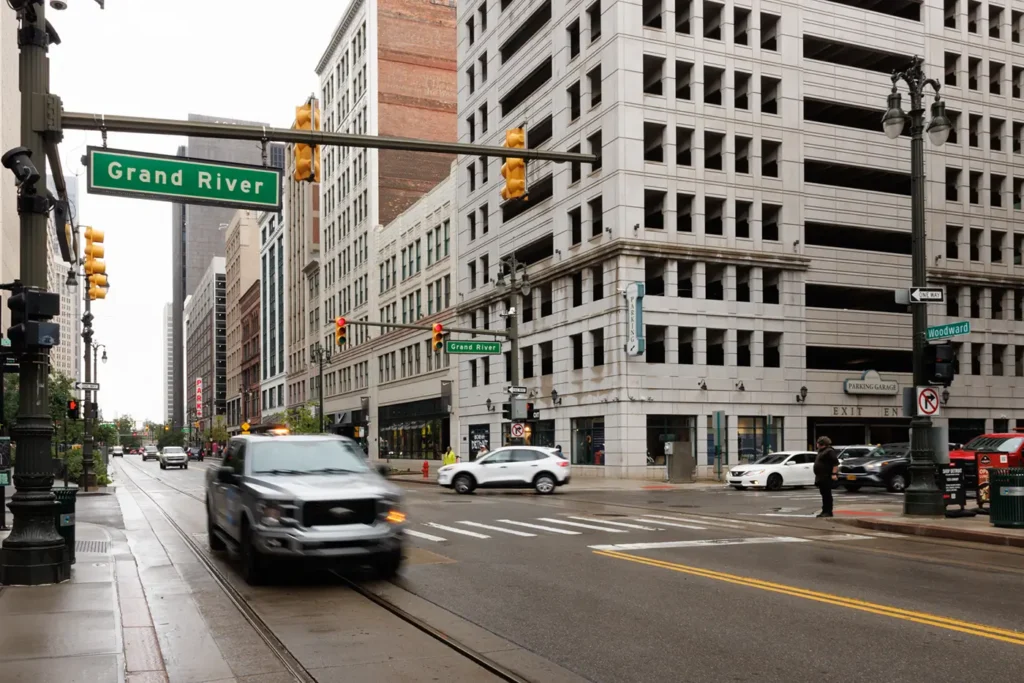 Cars driving in downtown Detroit near Grand River Avenue, where Michigan Auto Law helps rideshare crash victims as a Lyft accident lawyer in Detroit.