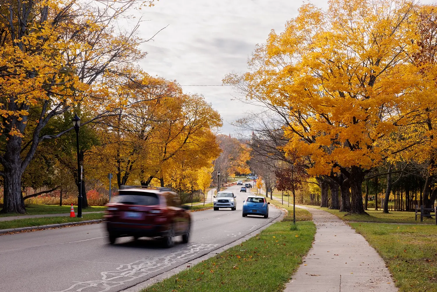 Cars travel along a tree-lined Traverse City road, showing Michigan Auto Law’s Lyft accident support.