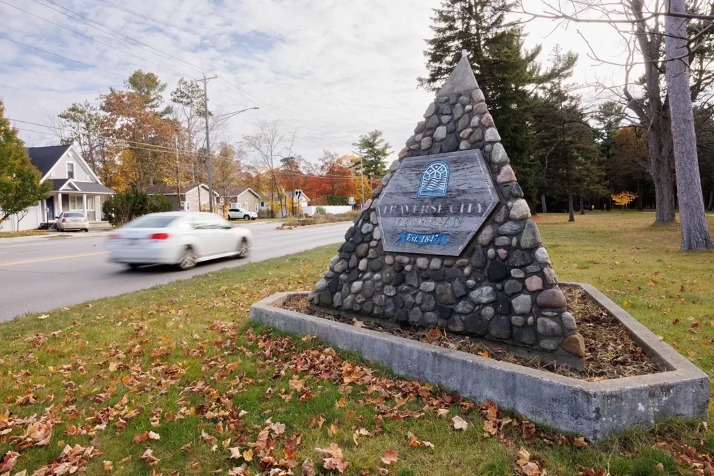 Car passing the Traverse City monument, showing the area Michigan Auto Law serves as a Lyft crash lawyer.