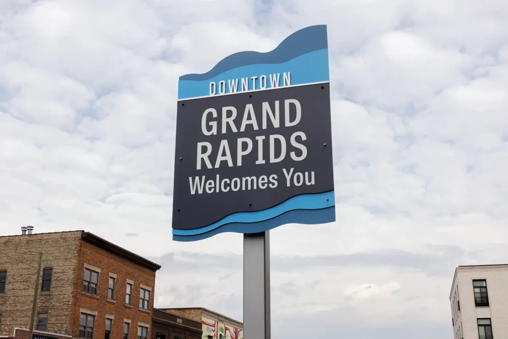 Downtown Grand Rapids sign beneath a cloudy sky, where Michigan Auto Law serves as a motorcycle accident attorney.