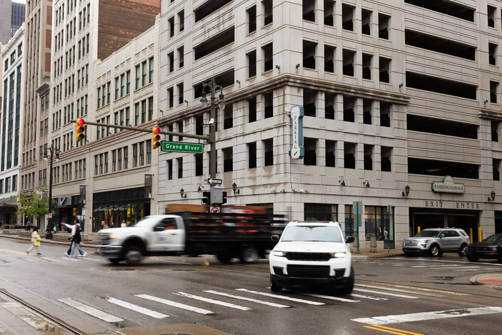 Busy downtown Detroit intersection with passing vehicles, representing the area served by Michigan Auto Law as an Uber accident attorney in Detroit.