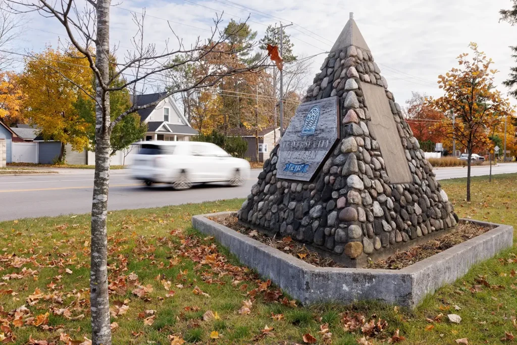 Cars pass entrance monument as Michigan Auto Law helps people after Uber-related accidents in Traverse City.