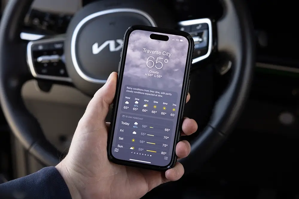 Driver checking the weather forecast, highlighting an important road trip safety check.