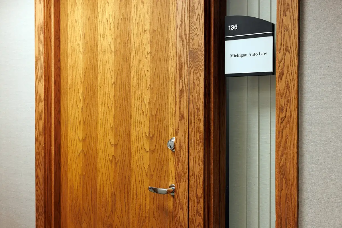 Office entrance with Michigan Auto Law suite sign, highlighting a car accident law firm Flint clients trust.