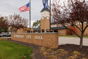 Clock tower and City Hall sign in Hudsonville depicting the area where Michigan Auto Law helps with car accident cases.