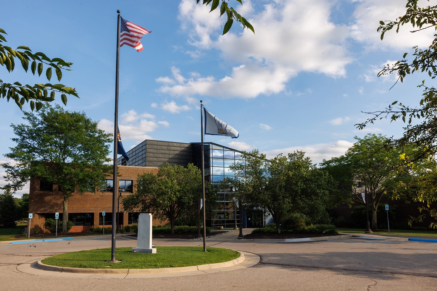 Novi civic building with flags, highlighting where Michigan Auto Law provides car accident law firm services.