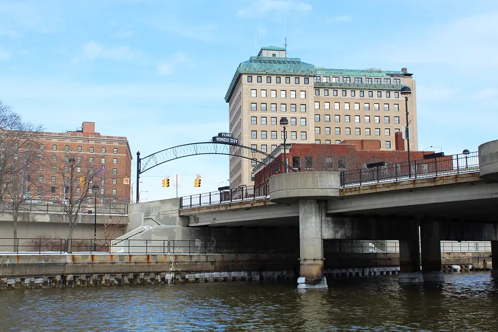 Riverfront with the Vehicle City arch, highlighting Michigan Auto Law, a truck accident law firm in Flint, MI.