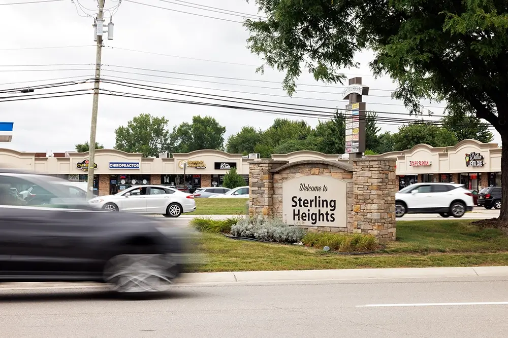  Welcome to Sterling Heights sign with passing traffic, highlighting roadways similar to those Michigan Auto Law's fatal crash lawyers handle.