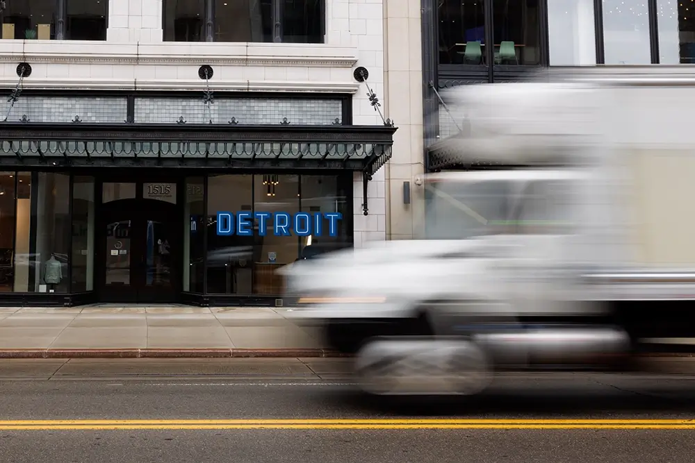 Downtown Detroit storefront with passing truck traffic, highlighting streets similar to those Michigan Auto Law's wrongful death lawyers handle.